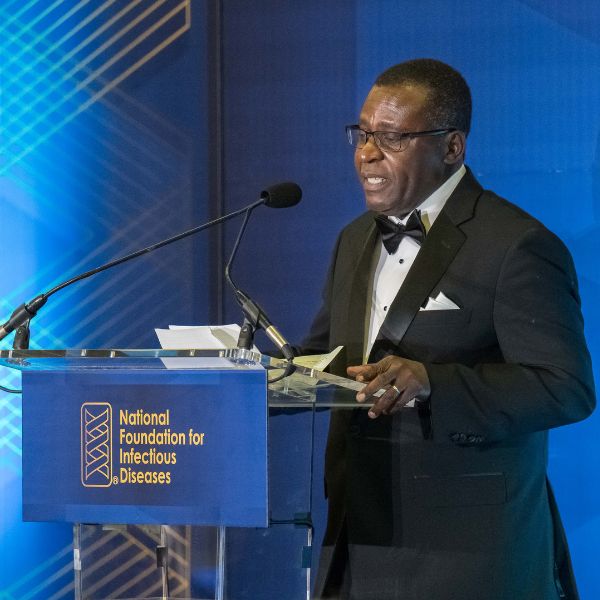 Igho Ofotokun stands at a podium addressing the audience